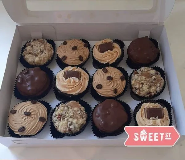 Caja con una variedad de cupcakes decorados